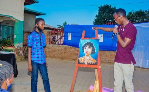 One beneficiary finished a painting and another guy looking at it