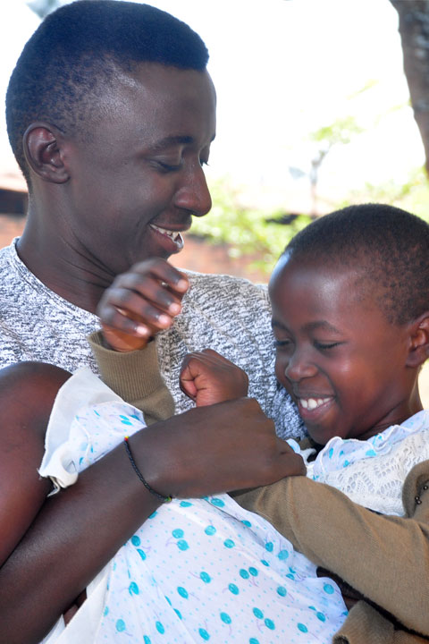 One guy holding a boy and they are smiling